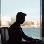 Profissional usando notebook com painéis de dados e interface digital, para o artigo Como usar inteligência artificial no ...